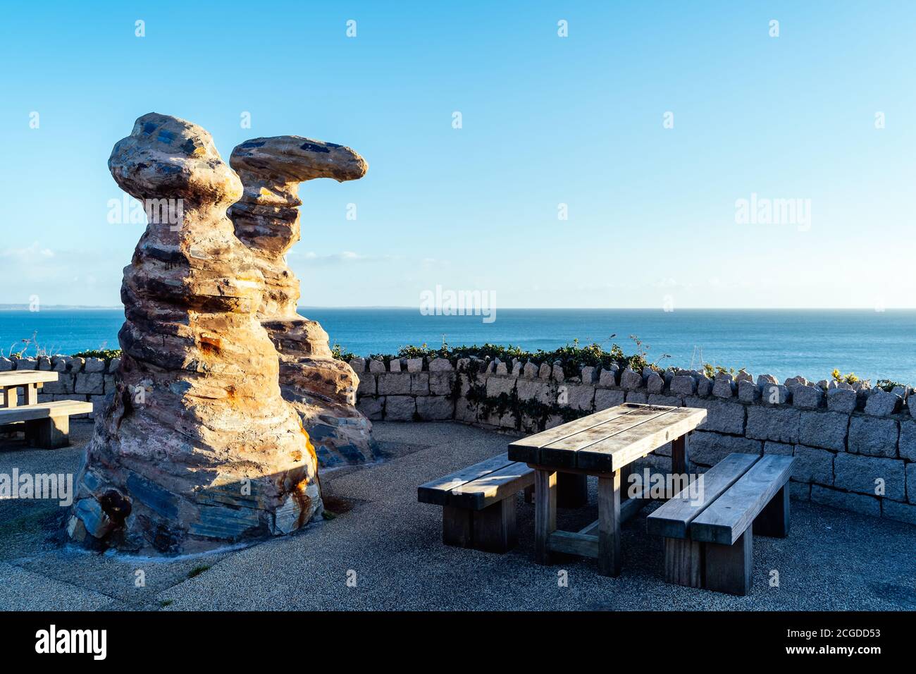 Table en bois et bancs avec formations rocheuses à proximité pour pique-niquer en bord de mer dans le port de plaisance de Greystones dans le comté de Wicklow, en Irlande Banque D'Images
