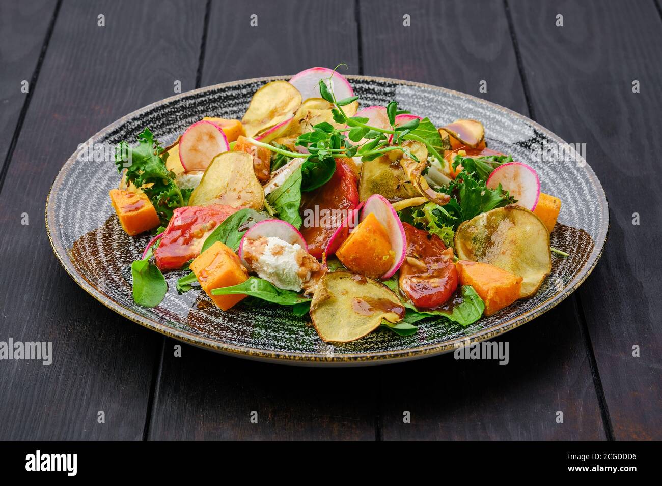 Portion de salade avec fromage doux, radis, poire, citrouille et tomate séchée au soleil Banque D'Images