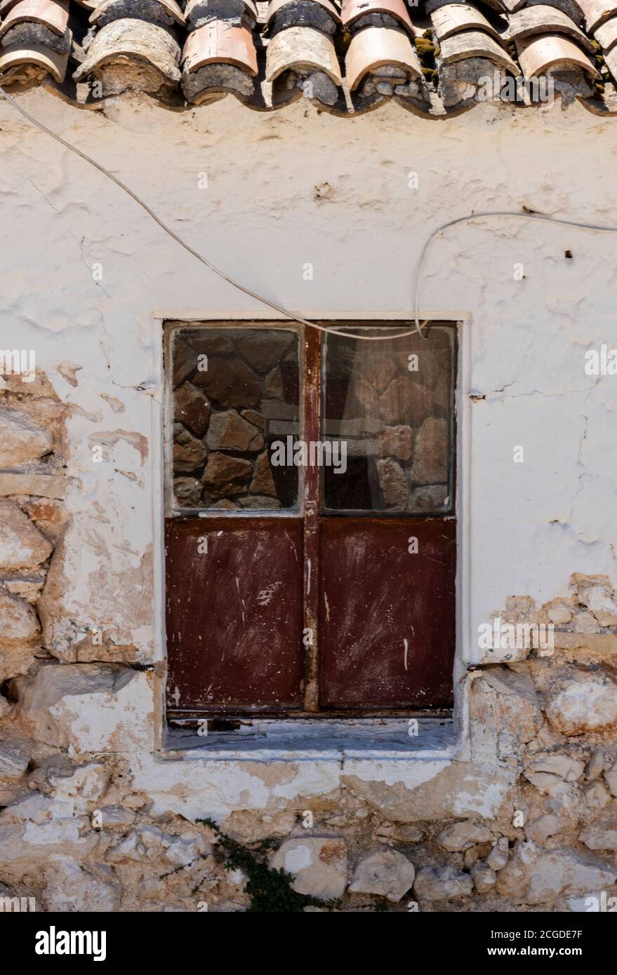 une vieille fenêtre cassée sur un mur délaqué sur un bâtiment sur l'île grecque de zante à zakynthos, grèce Banque D'Images