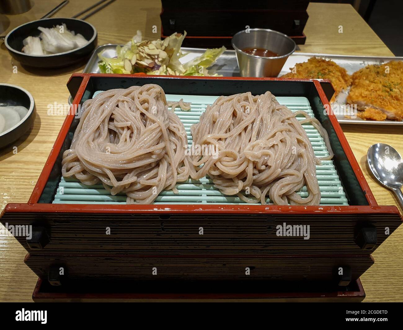 Soba, nouilles fines japonaises à base de farine de sarrasin. Mori Soba, nouilles de sarrasin réfrigérées de base servies sur un panier plat. Servi avec une sauce trempée. Banque D'Images