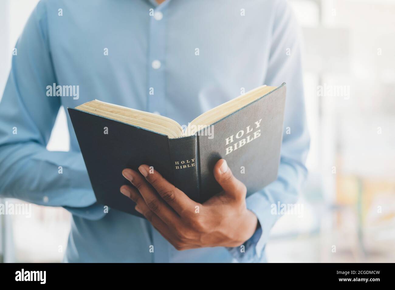 Religion concept de christianisme. Homme tenant et lisant la sainte Bible chrétienne. Banque D'Images