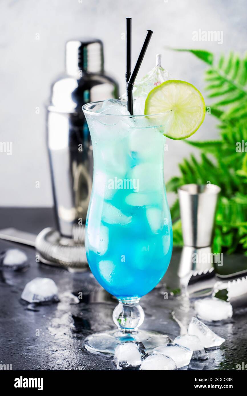 Blue Hawaiian ou Blue Lagoon - cocktail alcoolisé d'été avec vodka,  liqueur, tonique, jus d'ananas et glace, dans un verre à haut ouragan,  foyer sélectif Photo Stock - Alamy