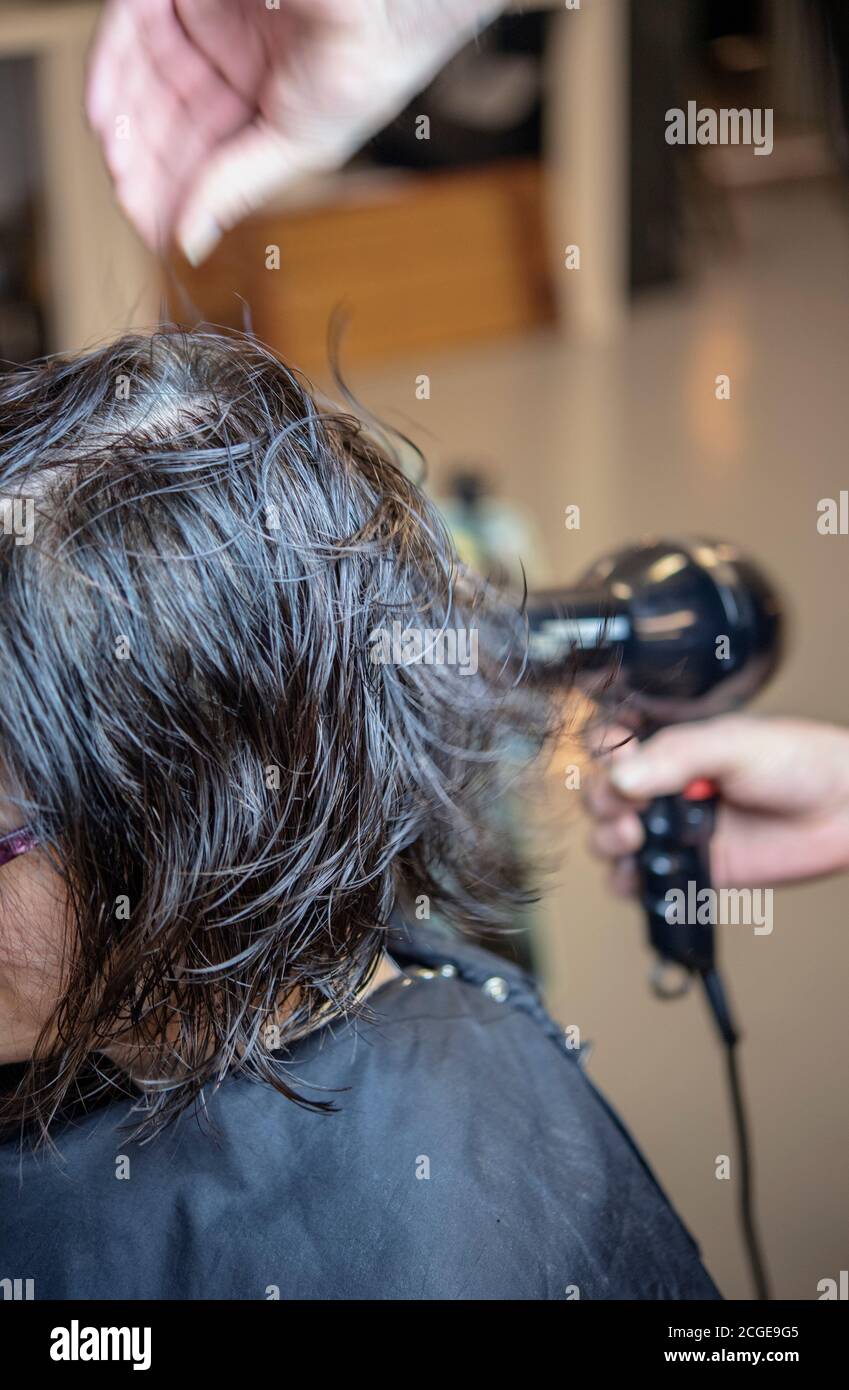 Femme qui a séché ses cheveux dans un salon de coiffure Banque D'Images