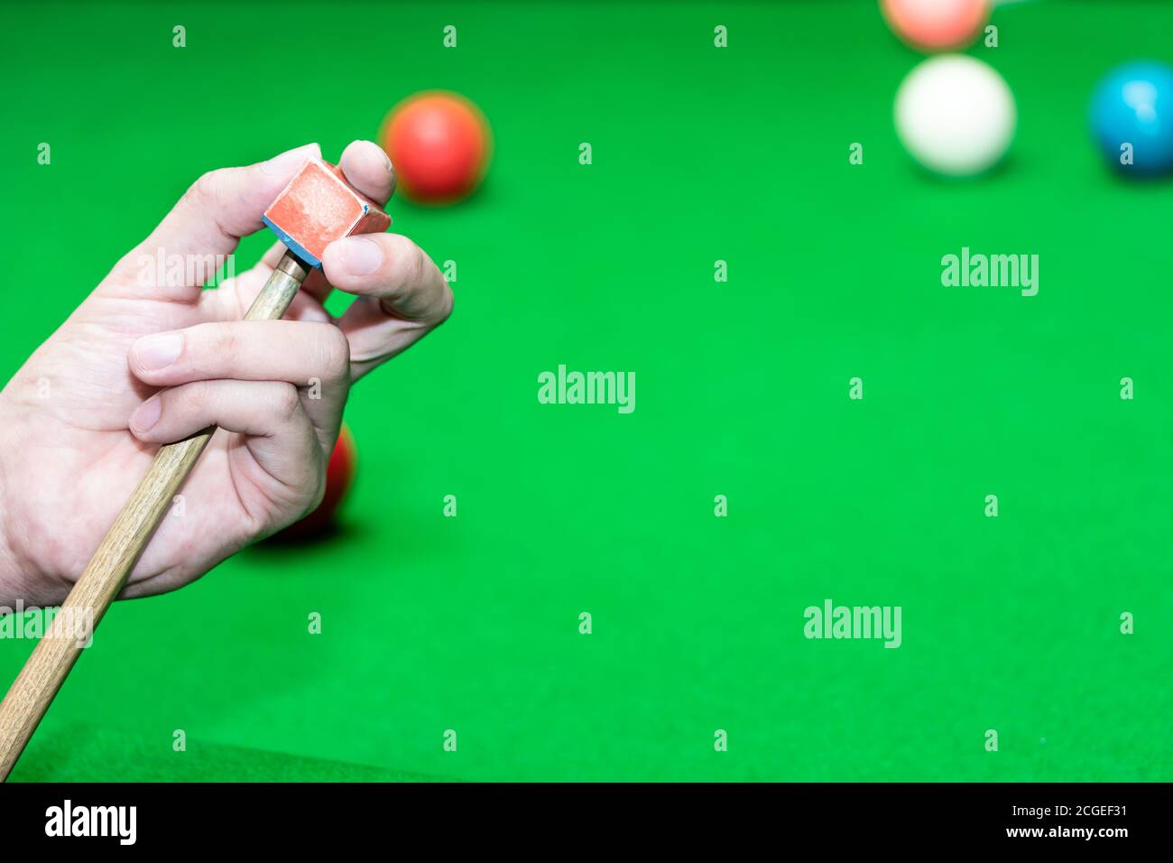 Gros plan du snooker du lecteur de main à l'aide d'un craie frottant un repère. Banque D'Images