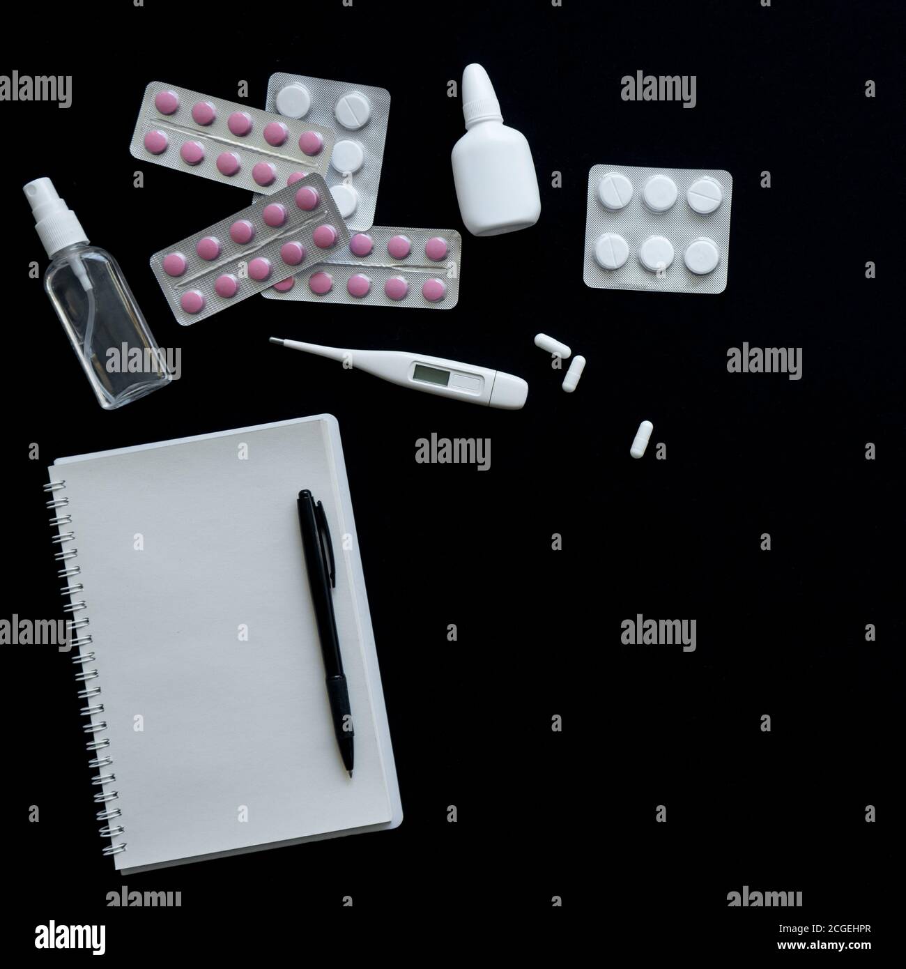 vue de dessus du thermomètre, des pilules et du carnet sur fond noir Banque D'Images