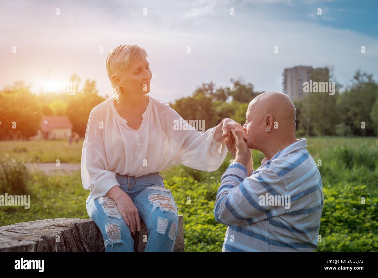 homme senior tenant et embrassant la main de femme le jour dedans stationnement Banque D'Images