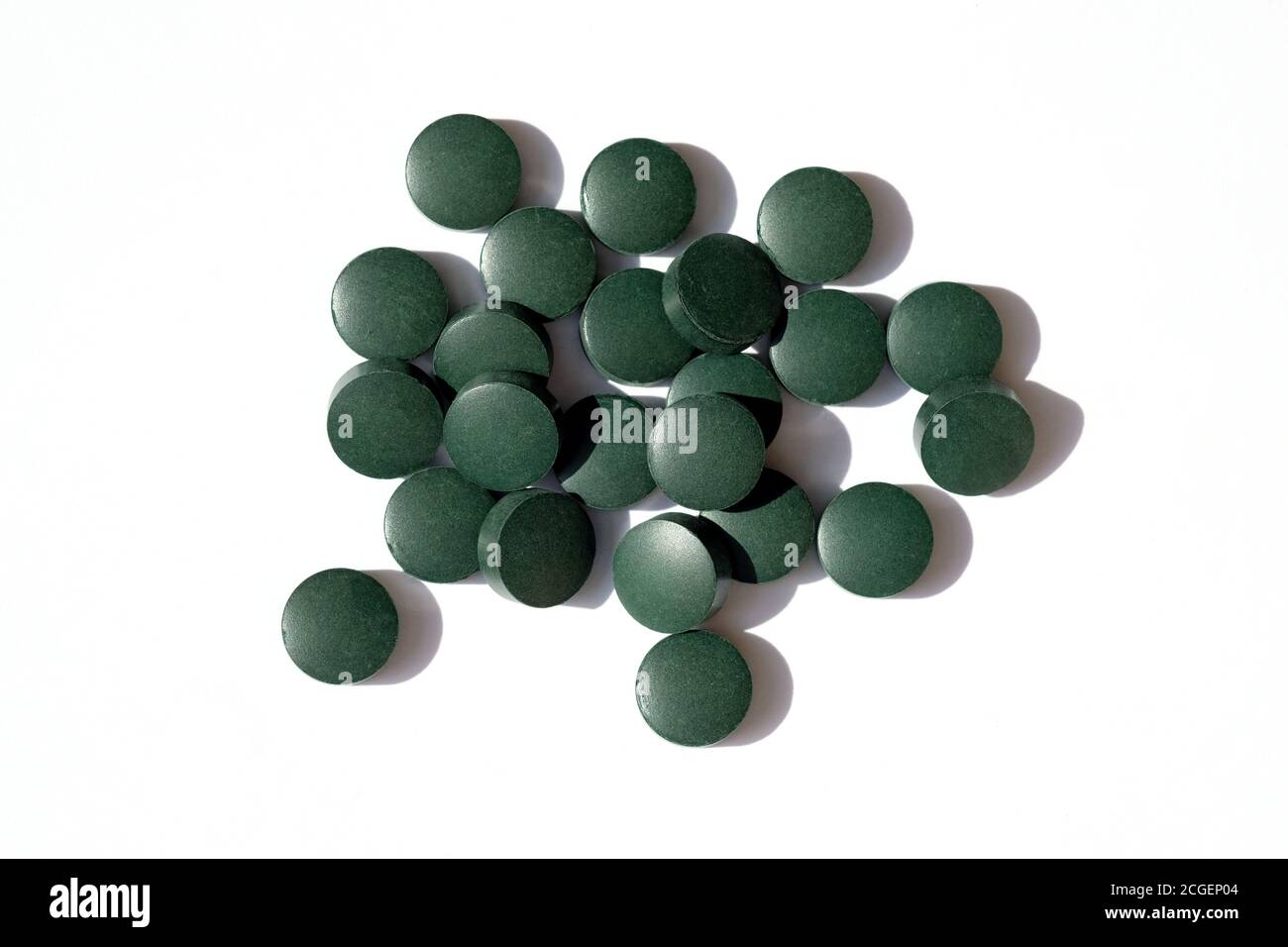 Arrondir les pilules vertes sur un fond blanc vue du dessus. Les comprimés de Chlorella sont des suppléments alimentaires. Spiruline sous forme de pilule. Banque D'Images