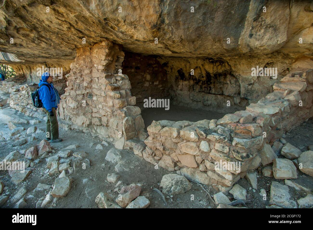 Un touriste (modèle relâché) aux habitations de la falaise de Sinagua à partir de 1100 après J.-C. au monument national de Walnut Canyon près de Flagstaff, Arizona, États-Unis. Banque D'Images