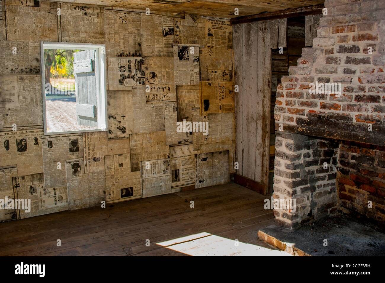 L'intérieur d'une cabine d'esclaves avec des journaux utilisés comme papier peint, à la plantation Magnolia et les jardins près de Charleston en Caroline du Sud, États-Unis. Banque D'Images