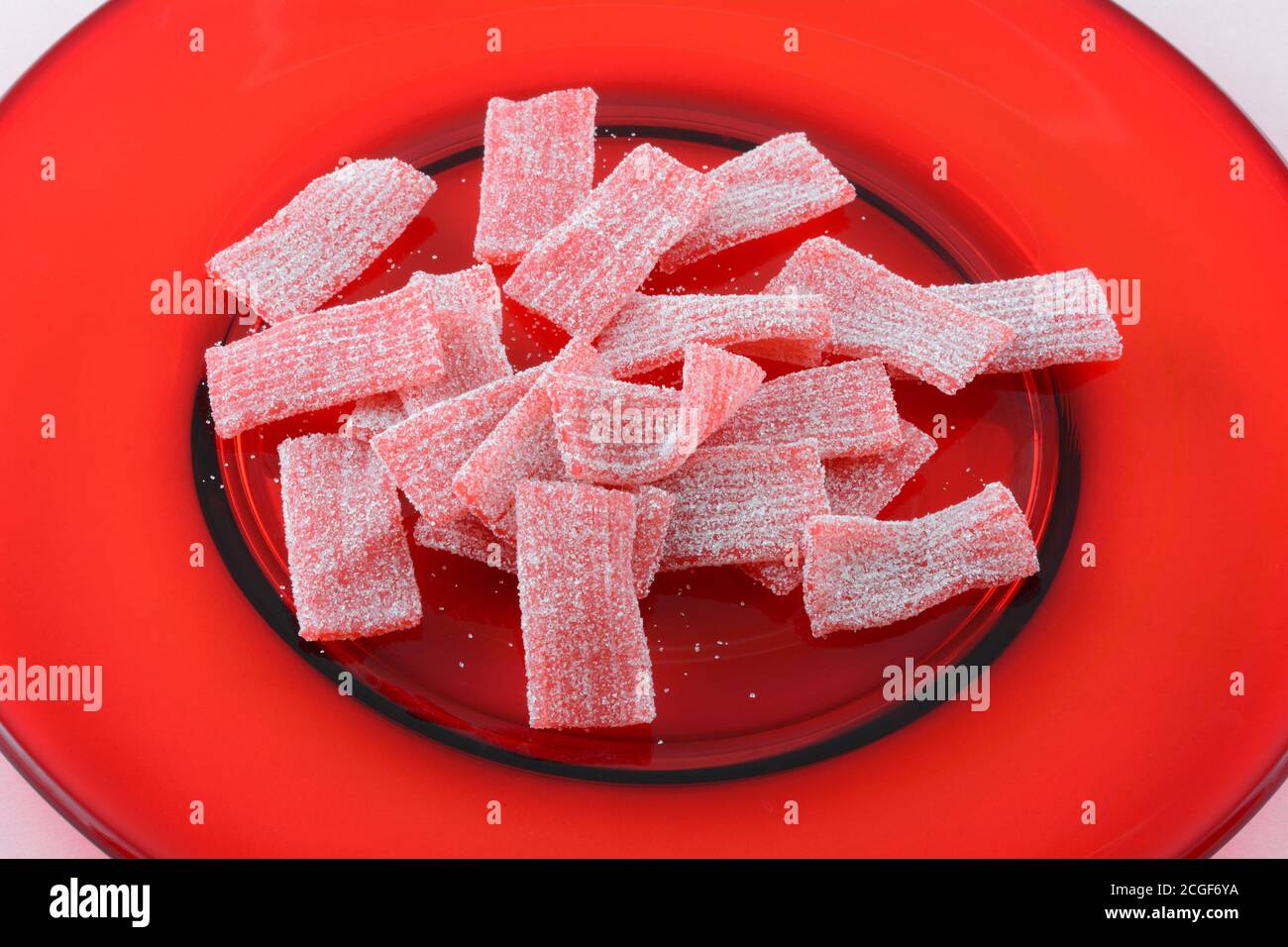 Gros plan de tapis de bonbons en gelée de légumes roses sur verre rouge  plaque Photo Stock - Alamy