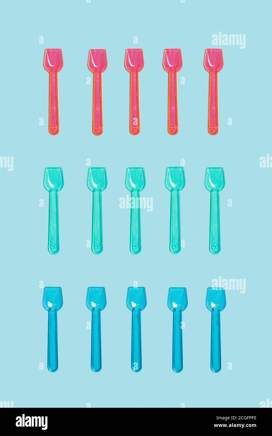 Cuillères à glace en plastique de couleur sur fond bleu clair Banque D'Images