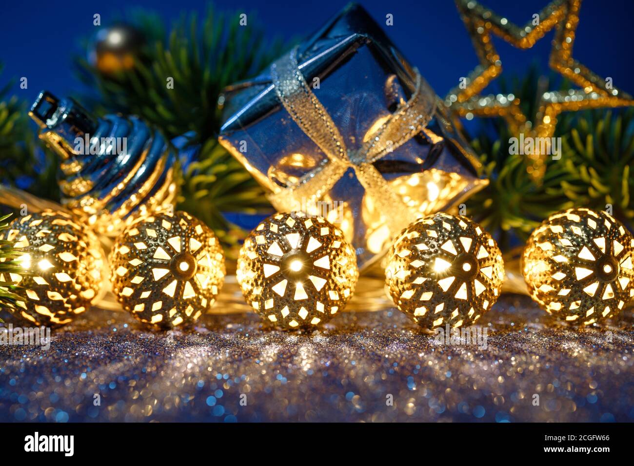 Guirlande dorée de Noël, cadeau et sapin avec décoration sur fond bleu. Banque D'Images