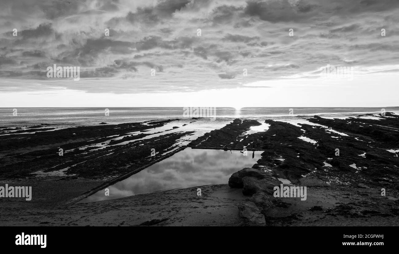 Paysage noir et blanc, littoral rocheux, Sunset Castle Sands Beach, St Andrews, Fife, Écosse, Royaume-Uni, GB. Banque D'Images