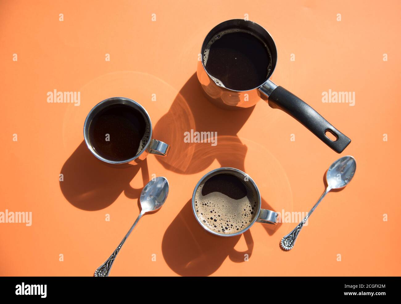 Deux tasses de café et des pots sur fond orange lors d'une matinée ensoleillée. Petit déjeuner.orientation horizontale Banque D'Images