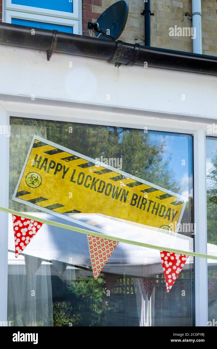 Banderoles et banderoles de fête lors d'une fête d'anniversaire en plein air socialement distancée. L'affiche indique « Happy Lockdown Birthday ». Banque D'Images
