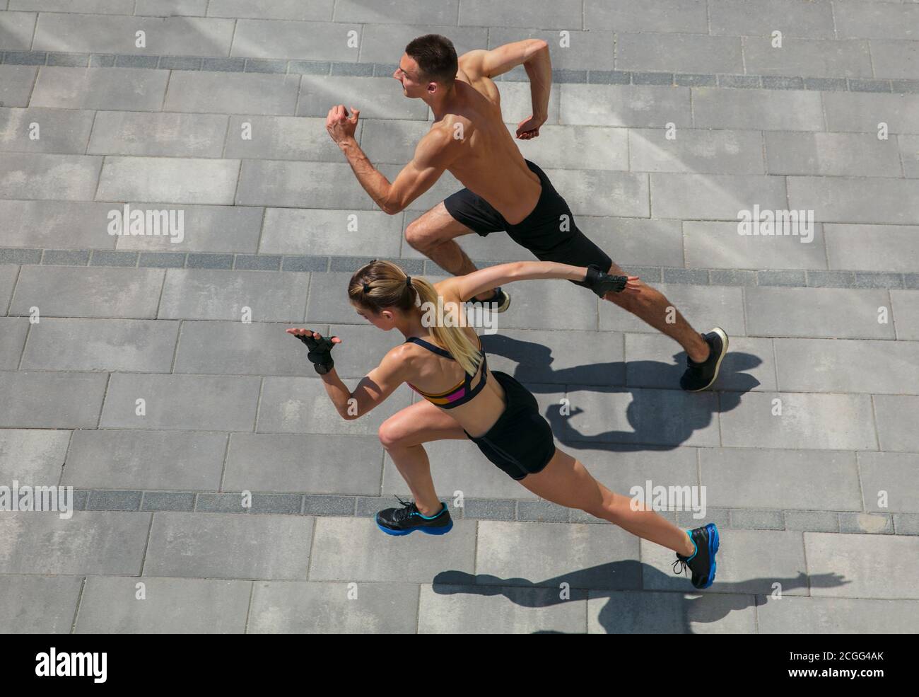 Fort. Jeune couple en tenue de sport faisant l'entraînement matinal à  l'extérieur. Homme et femme faisant des exercices cardio et de force,  pratiquant l'activité pour le bas et le haut du corps.