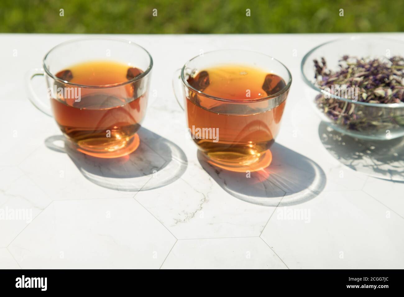 Thé de Chamaenerion angustifolium (cyprès, saule rose, thé Ivan) avec fleurs sèches et fraîches pour la décoration dans deux tasses en verre sur fond clair. Con Banque D'Images