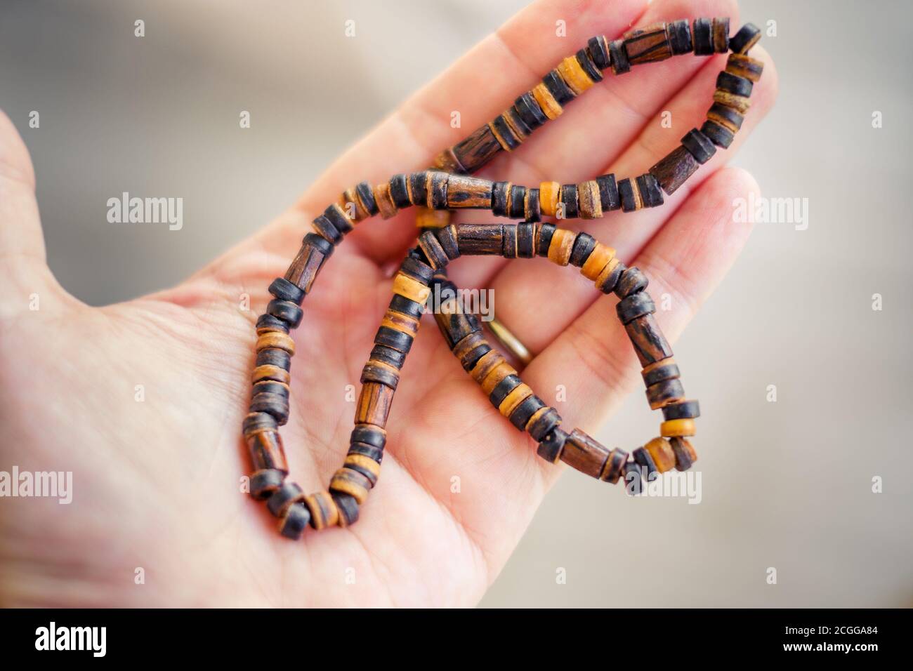 homme main tenir collier traditionnel en bois fond Banque D'Images