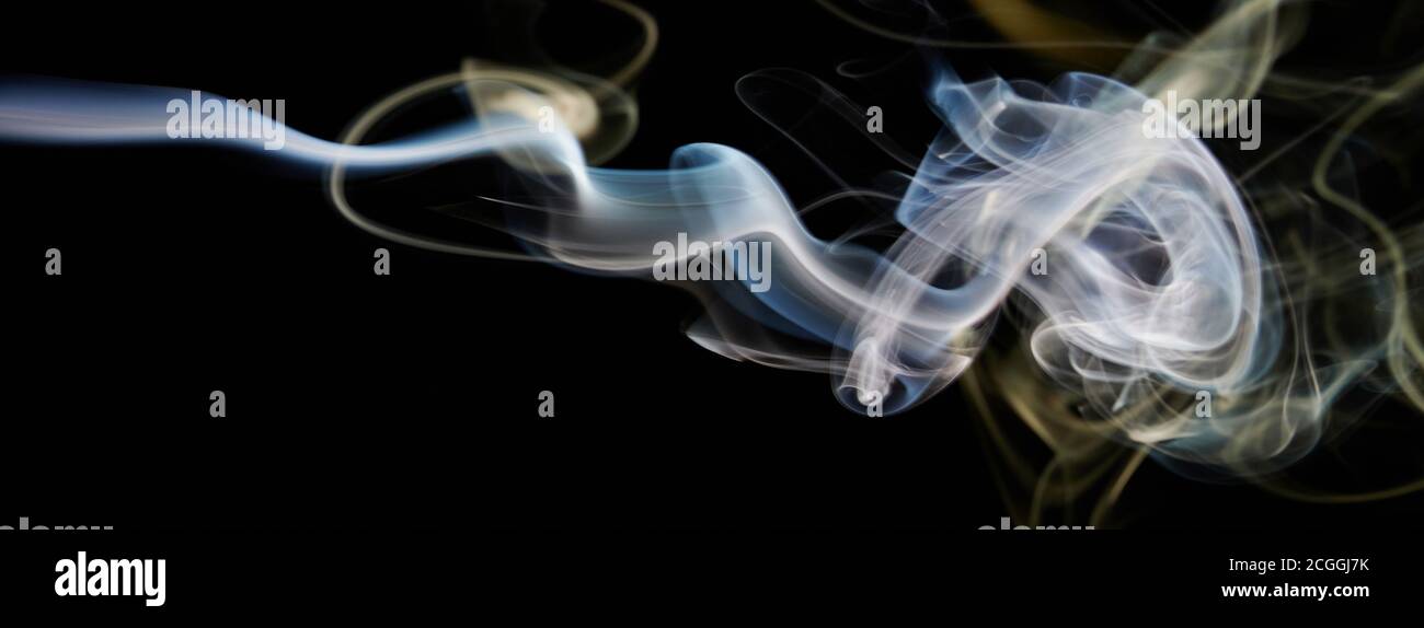 Flux de fumée lisse et coloré sur fond noir isolé Banque D'Images