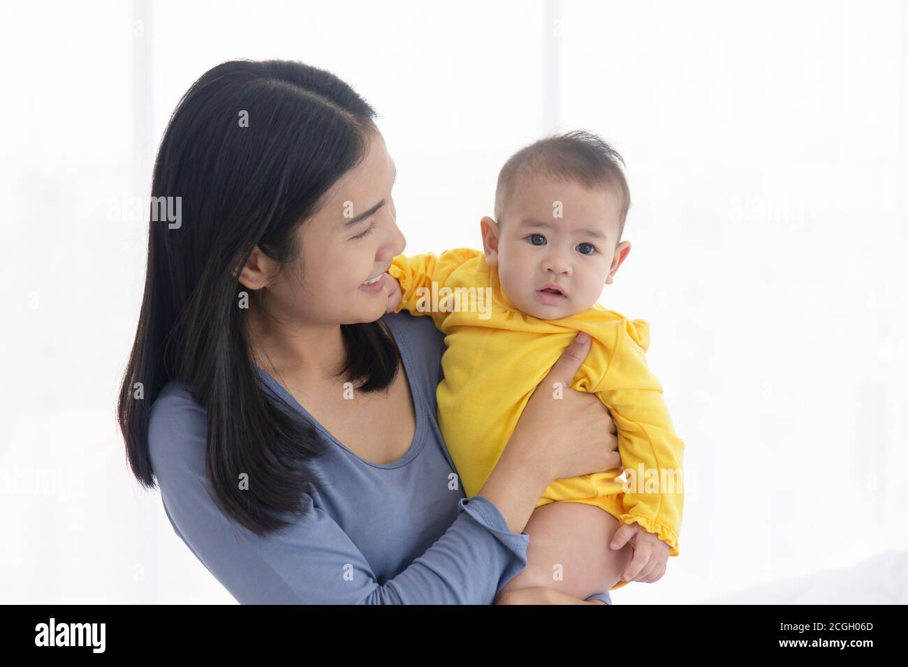 Une mère asiatique porte son bébé avec amour et soin. Banque D'Images