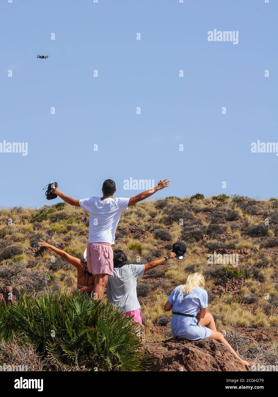 Groupe d'amis prenant un selfie et filmant eux-mêmes avec un drone volant à la campagne Banque D'Images