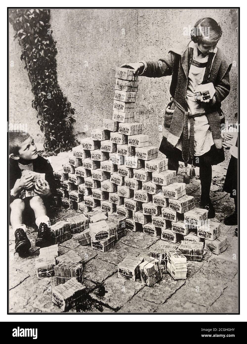 Les archives des années 1920 hyperinflation Allemagne, les enfants utilisant des billets de banque comme jouets, Allemagne, années 1920. Entre 1921 et 1923, l'hyperinflation a affecté le Papiermark allemand, la monnaie de la République de Weimar, principalement en 1923. Elle a provoqué une instabilité politique interne considérable dans le pays, l'occupation de la Ruhr par la France et la Belgique ainsi que la misère de la population en général. Imprimer plus d'argent est exactement ce que l'Allemagne de Weimar a fait en 1922. Pour répondre aux réparations alliées, ils ont imprimé plus d'argent, ce qui a causé l'hyperinflation des années 1920. L'hyperinflation a conduit à l'effondrement de l'économie. Banque D'Images
