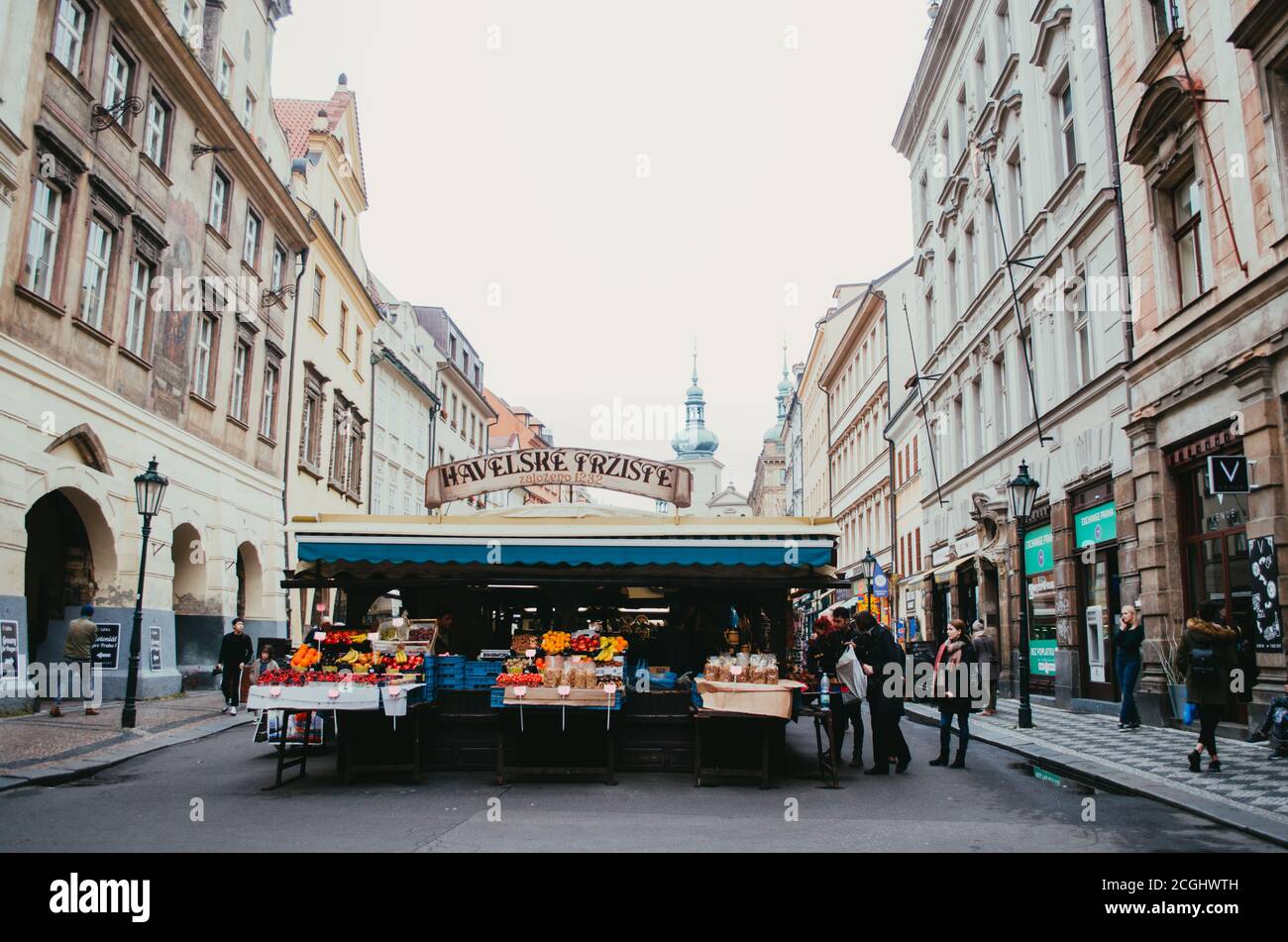 Prague, Tchéquie - vue de face du Havelské tržiště, le plus ancien marché de la capitale, avec des kiosques vendant des fruits et des céréales avec quelques clients Banque D'Images
