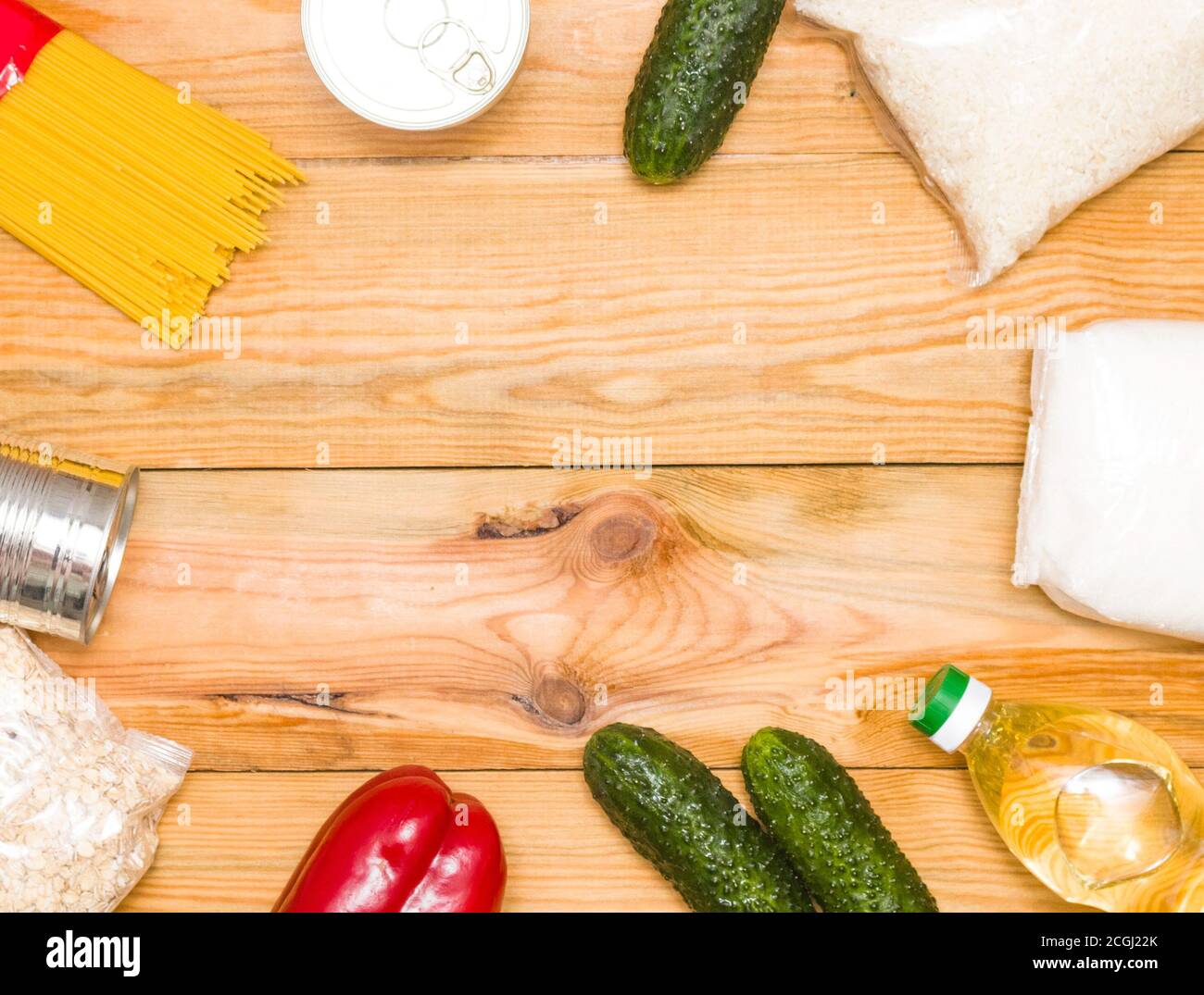 Dons alimentaires sur fond de bois, vue du dessus avec espace pour les copies. Beurre, céréales, conserves. Les produits de la première nécessité. Banque D'Images