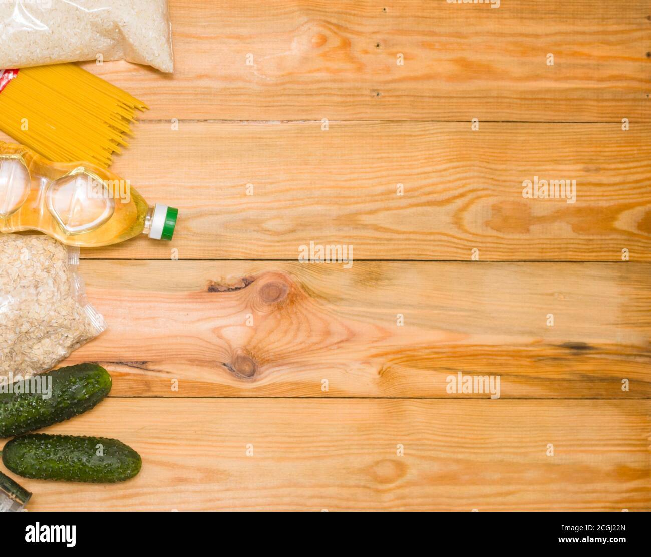 Dons de nourriture sur un fond en bois sur le côté, vue du dessus avec espace de copie. Beurre, céréales, conserves. Les produits de la première nécessité. Banque D'Images