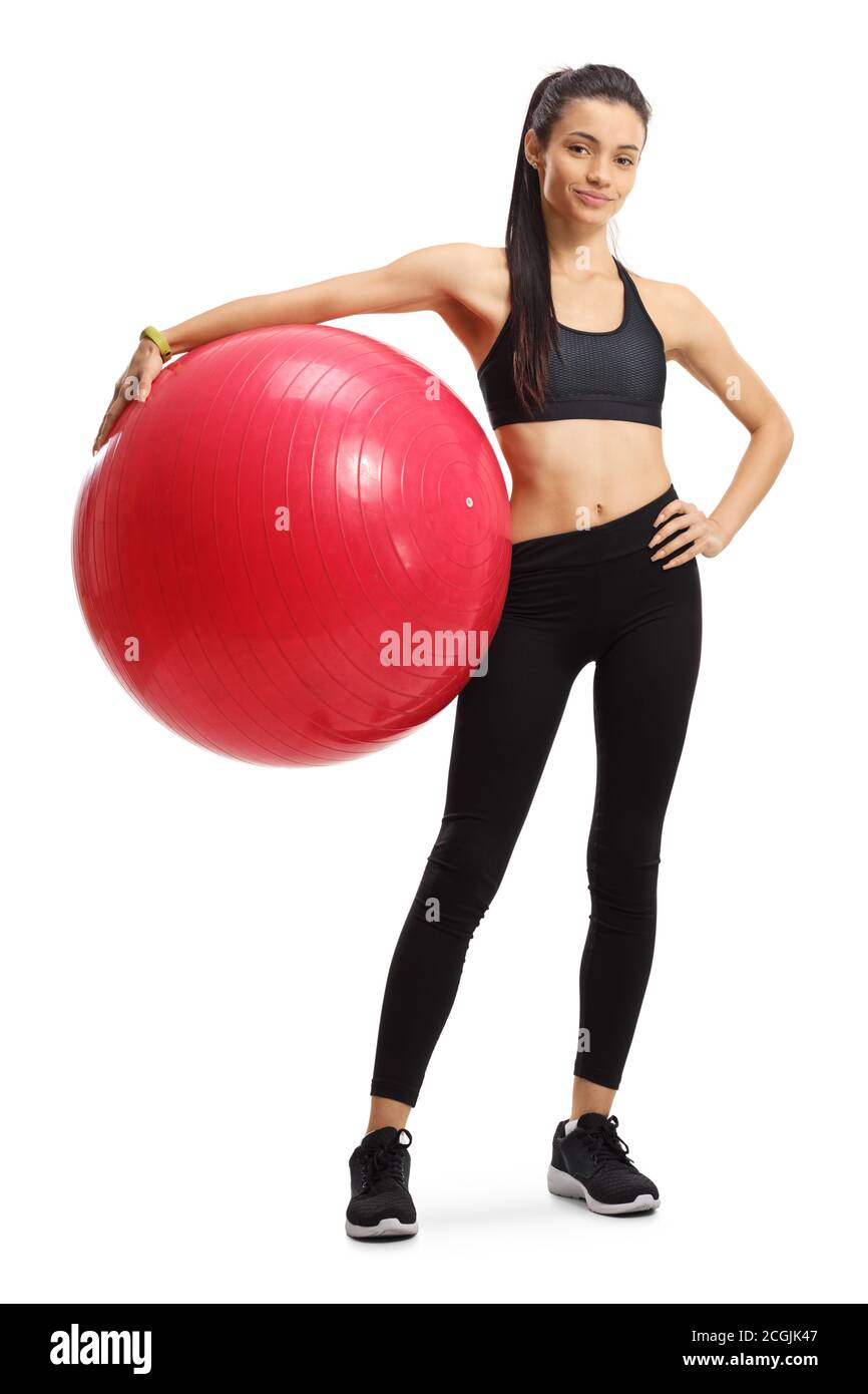 Portrait d'une jeune femme en tenue de sport ballon de fitness rouge isolé sur fond blanc Banque D'Images