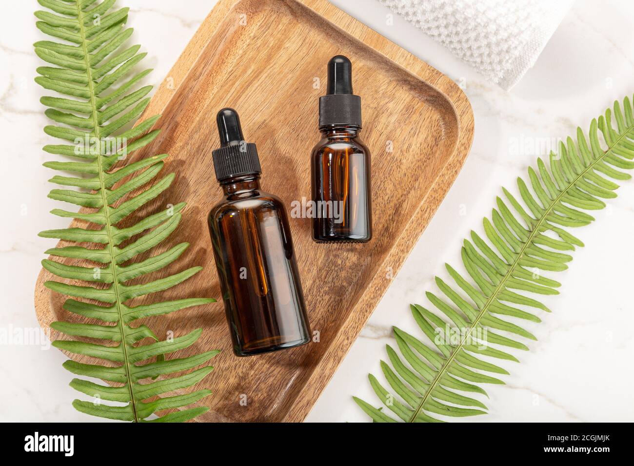 Bouteille d'huile essentielle sur plateau en bois Beauté, soins de la peau, bien-être Banque D'Images