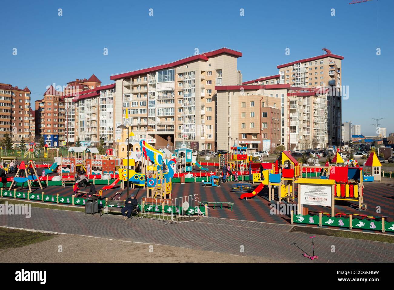 Les enfants avec leurs parents jouent sur une aire de jeux publique dans un quartier résidentiel de ​​Krasnoyarsk par une belle journée d'automne. Banque D'Images