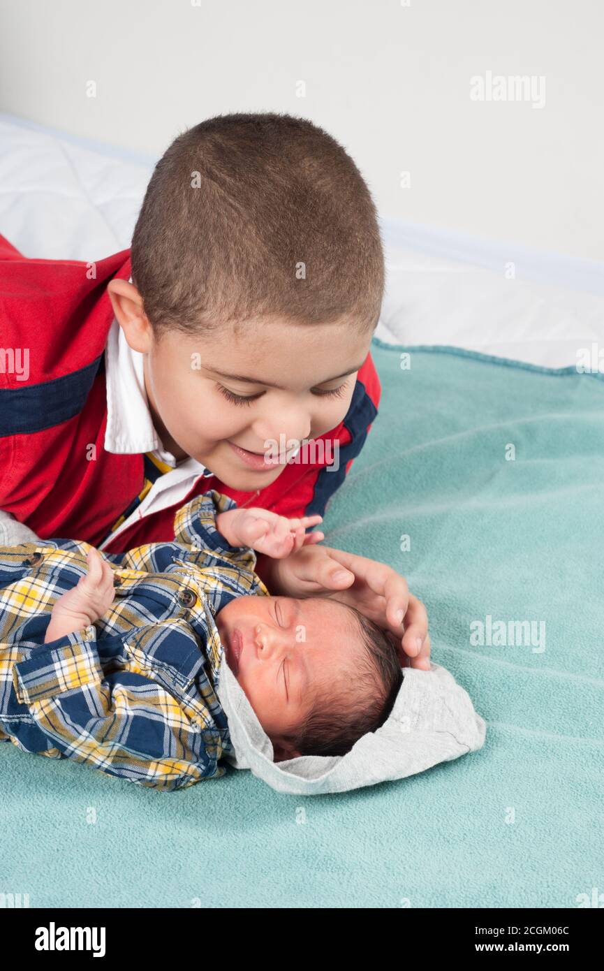 Nouveau-né garçon, 1 semaine admiré par un frère âgé de 6 ans, touchant doucement sa tête pendant qu'il dort Banque D'Images