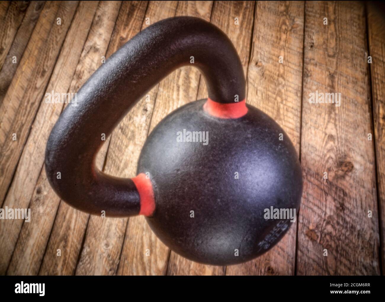 une lourde kettlebell en fer flottant sur un fond de bois rustique - concept de fitness, image de mise au point douce prise avec un appareil photo à trou d'épingle sans lensless Banque D'Images