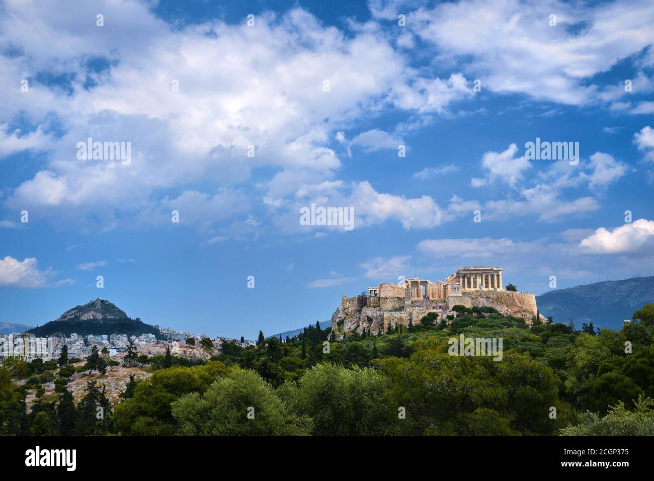 Vue emblématique de la colline de l'Acropole et de la colline du Lycabette en arrière-plan à Athènes, Grèce depuis la colline de Pnyx en été, avec de grands nuages dans le ciel bleu. Banque D'Images