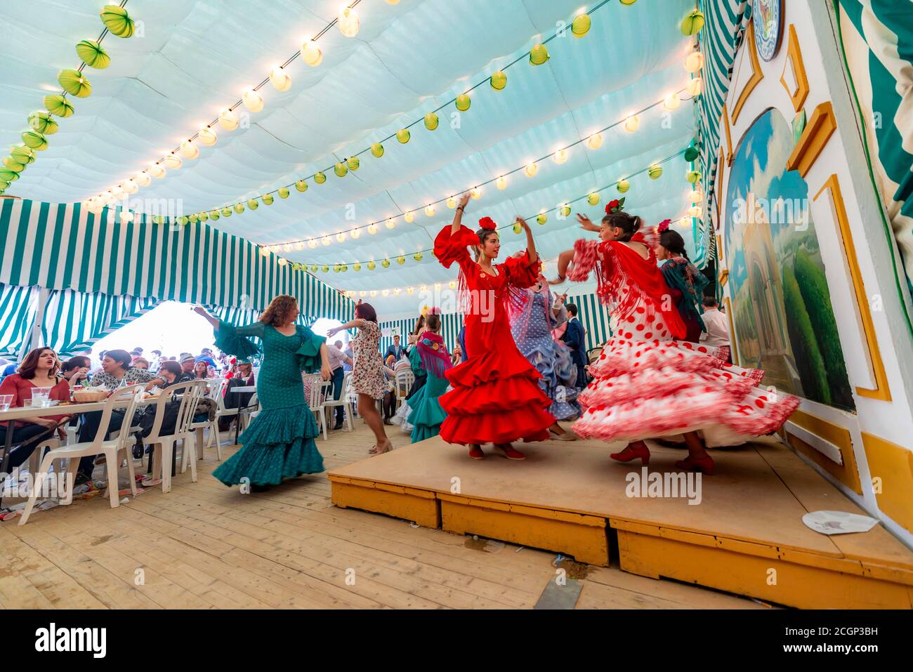Jeune femme dansant Sevillano, femme espagnole avec des robes de flamenco dans le chapiteau coloré, Casetas, Feria de Abril, Séville, Andalousie, Espagne Banque D'Images