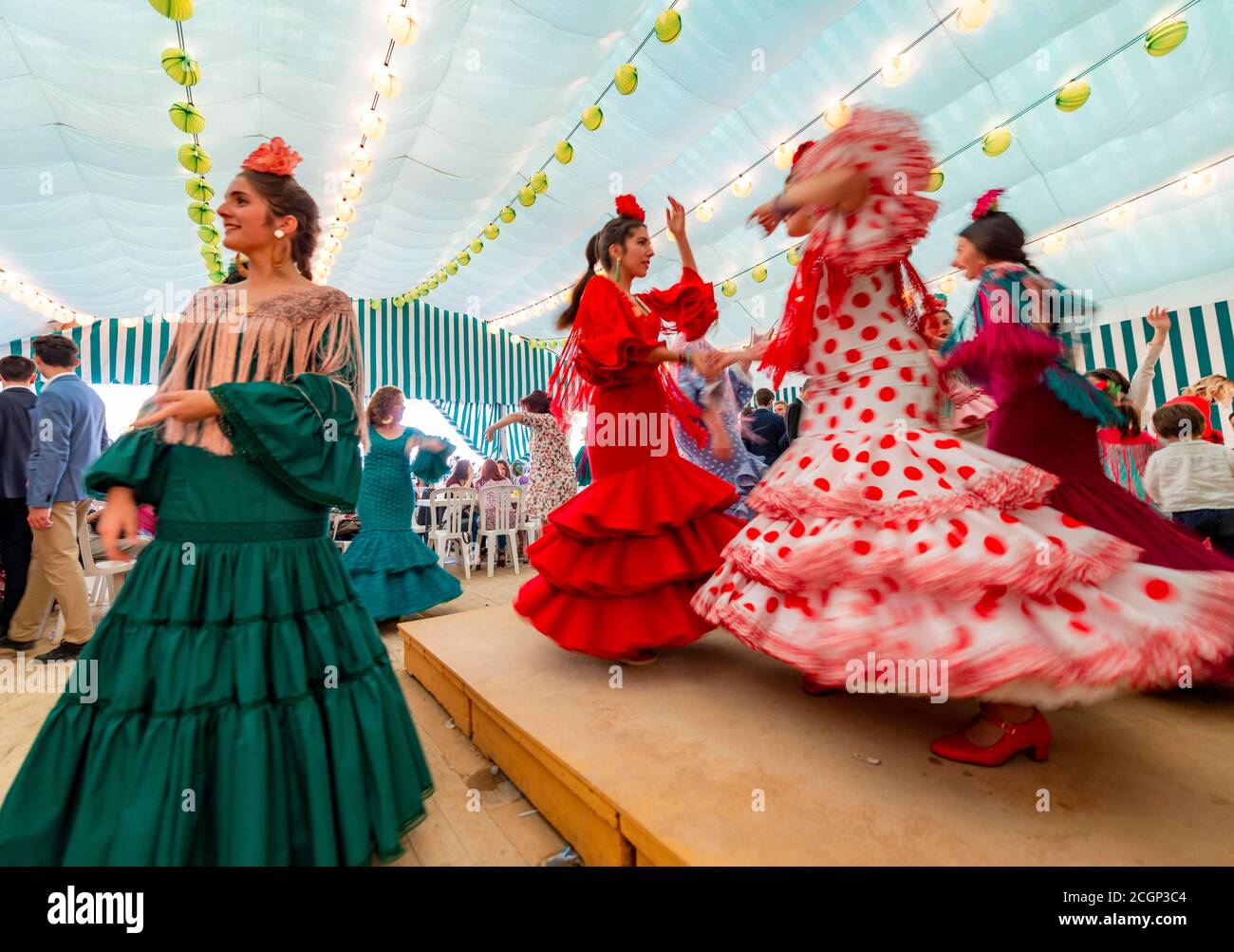 Jeune femme dansant Sevillano, femme espagnole avec des robes de flamenco dans le chapiteau coloré, Casetas, Feria de Abril, Séville, Andalousie, Espagne Banque D'Images