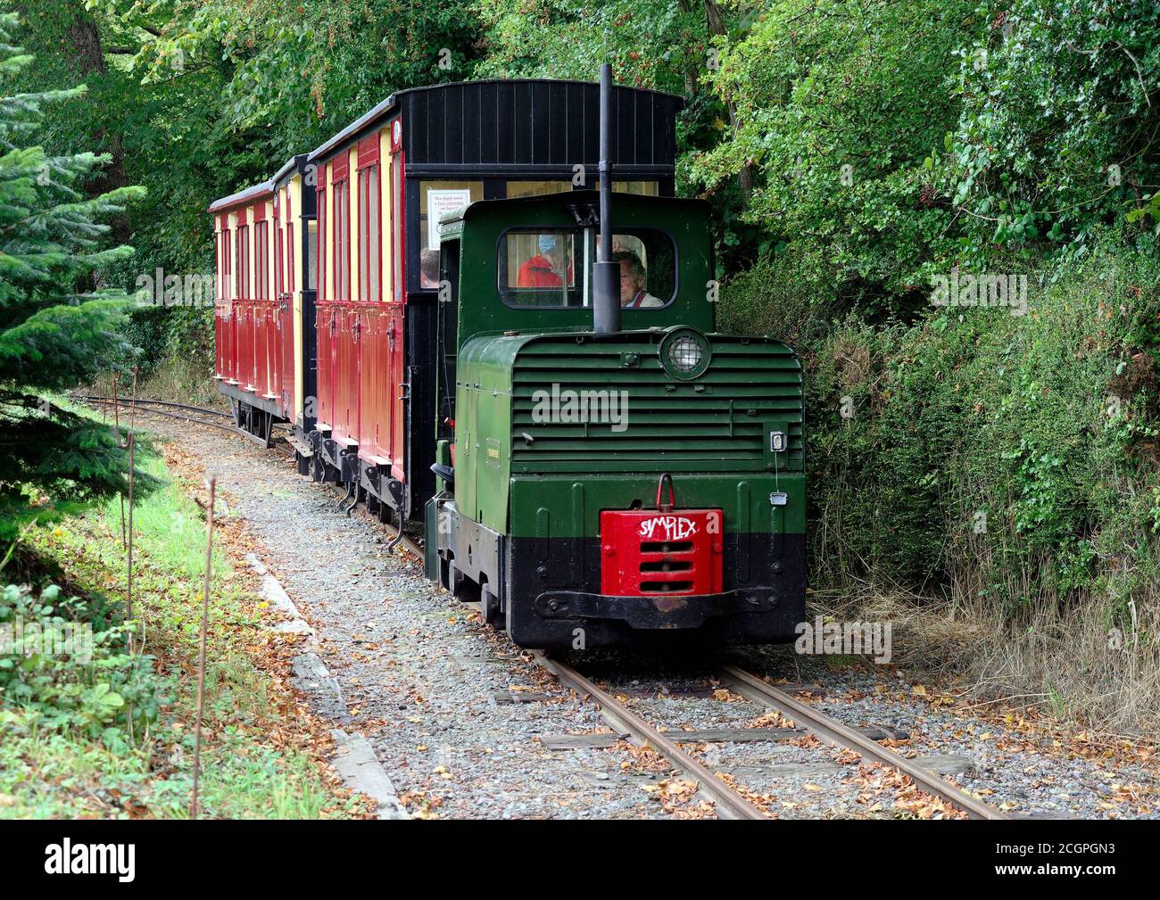 Un train sur le chemin de fer à voie étroite au musée du transport East Anglian près de Lowestoft transporté par une locomotive industrielle Simplex. Banque D'Images