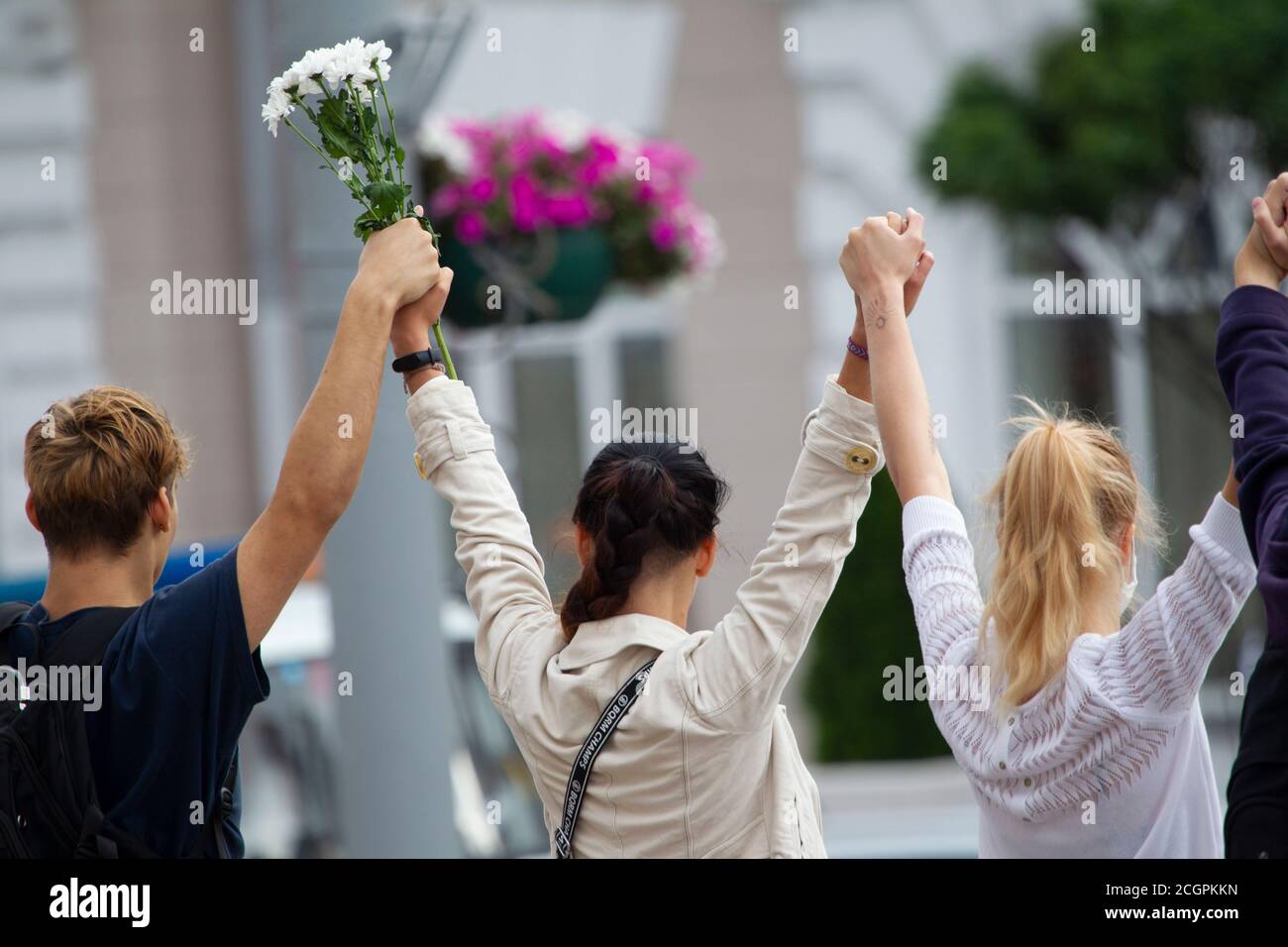 Biélorussie contre le dictateur. Les femmes avec des fleurs ont levé les mains. Banque D'Images