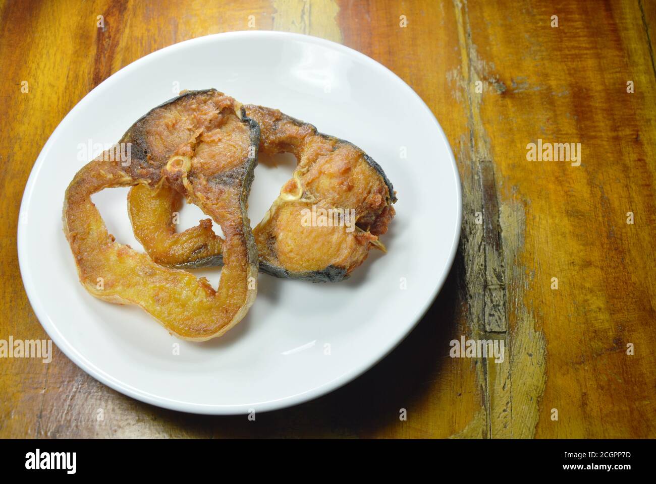 tranche de poisson-chat rayé salé frit sur une assiette blanche Banque D'Images