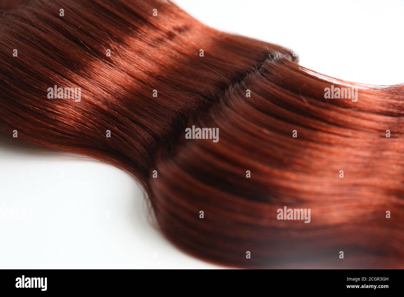 pièce de cheveux ondulée red auburn isolée sur fond blanc Banque D'Images