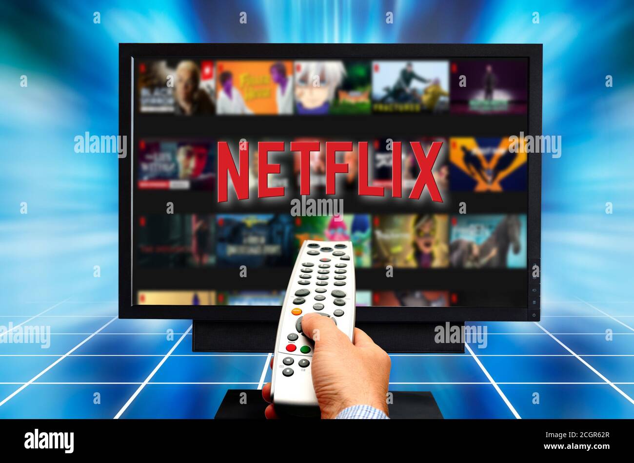 main tenant la télécommande et choisissant un programme à regarder netflix Banque D'Images