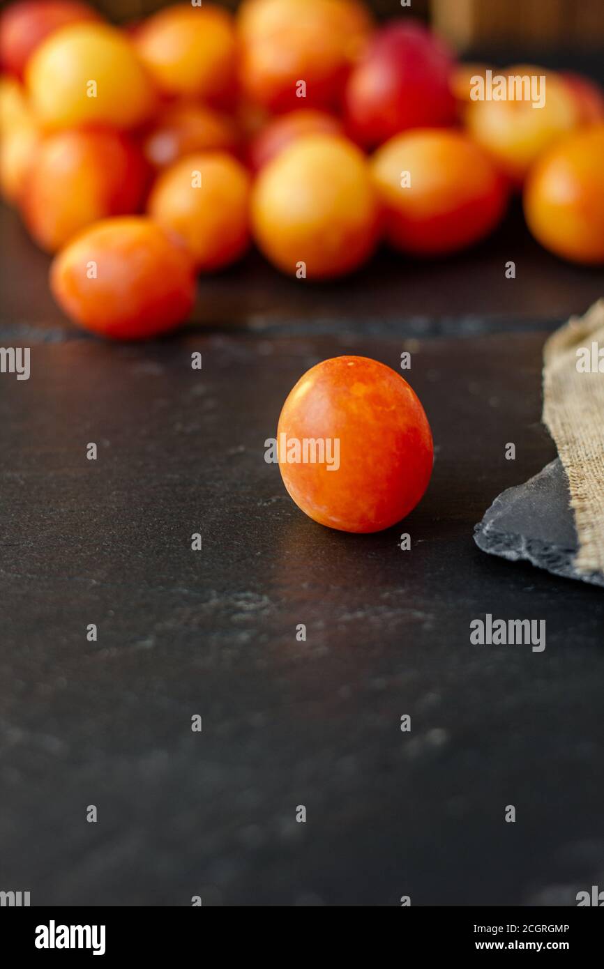 Prune sauvage fraîche et mûre ou prune cerise sur une surface noire Banque D'Images