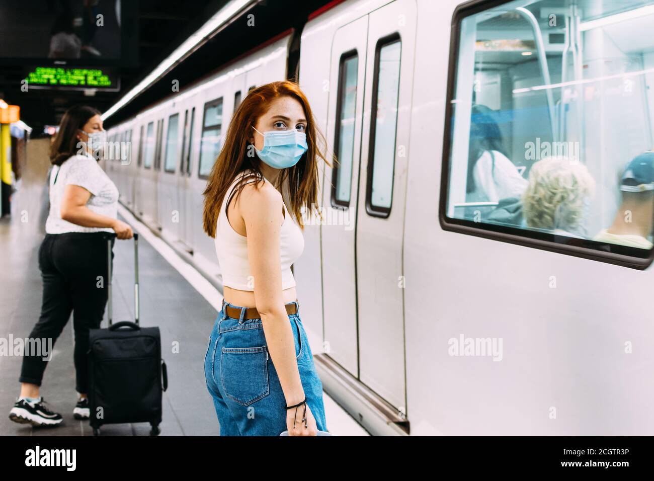 jeune femme avec un masque facial attendant le métro Banque D'Images