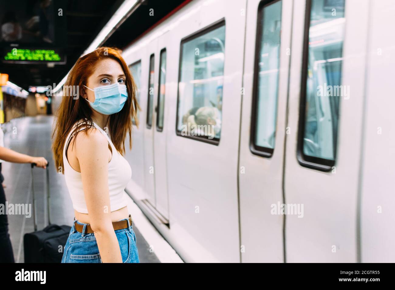 jeune femme avec un masque facial attendant le métro Banque D'Images