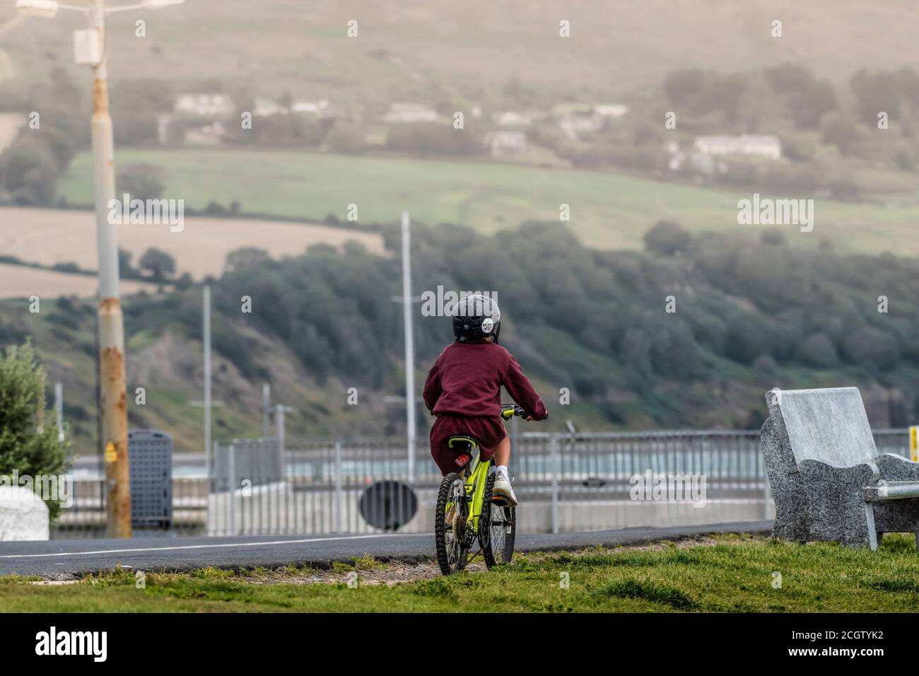 Scène de rue de style de vie. Garçon dans l'uniforme de l'école à vélo à l'école. Banque D'Images