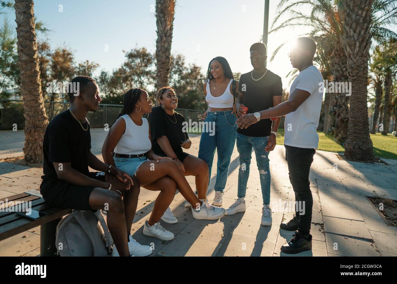 Groupe de jeunes amis noirs africains modernes heureux de s'asseoir ensemble Banque D'Images