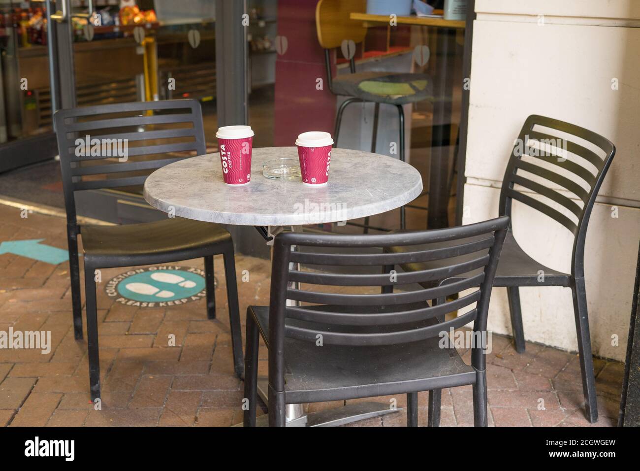 Table et chaises à l'extérieur d'un Costa Cafe avec des tasses vides. Londres Banque D'Images