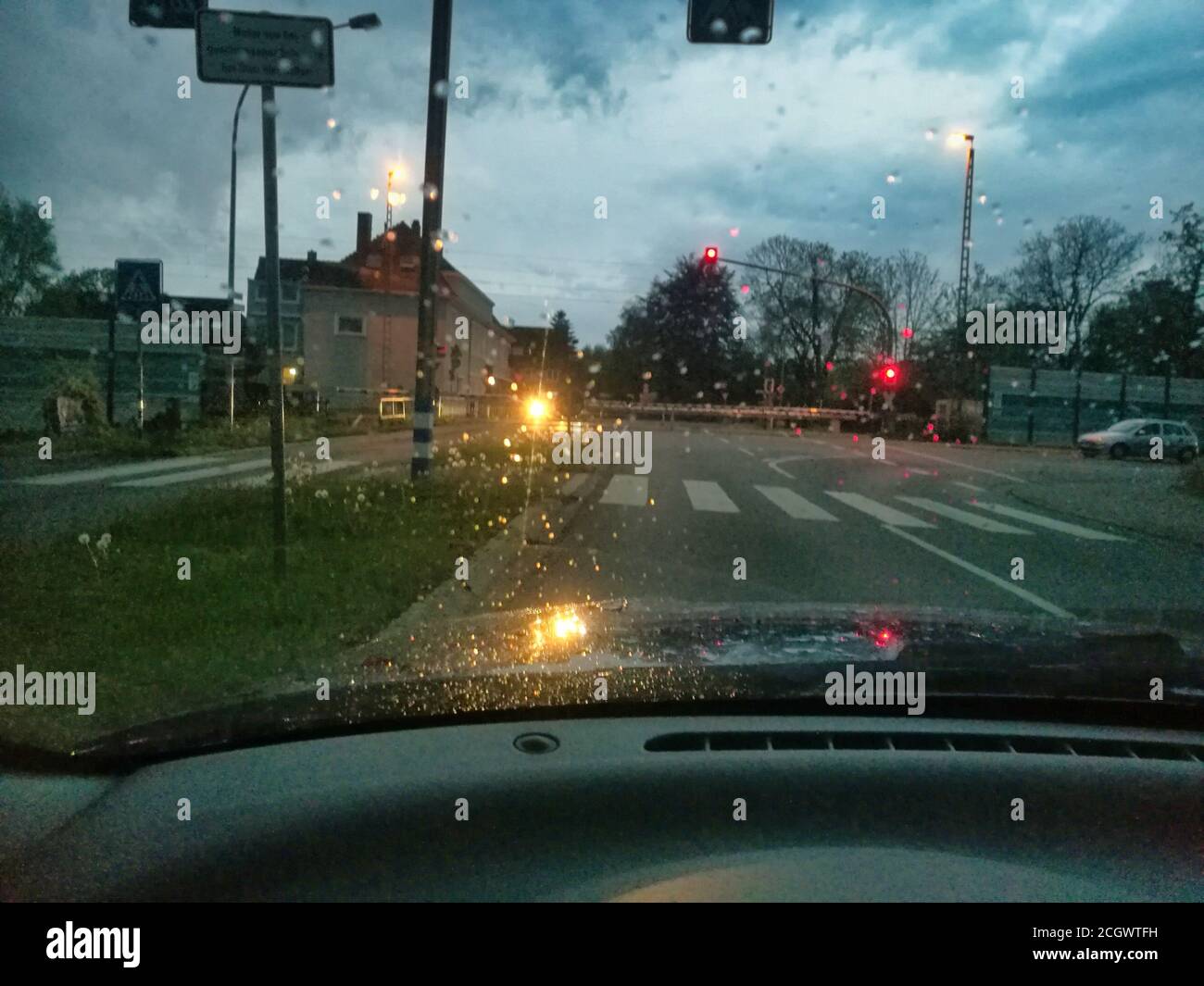 Barrières fermées d'un passage de chemin de fer sous la pluie Banque D'Images