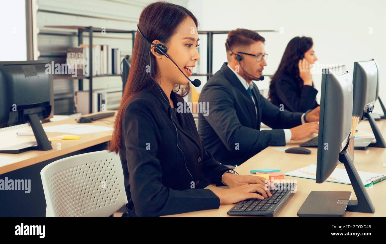 Les professionnels portant un micro-casque travaillant au bureau pour aider les clients ou collègues distants. Centre d'appels, télémarketing, agent d'assistance clientèle fournissent un service de vidéoconférence par téléphone. Banque D'Images